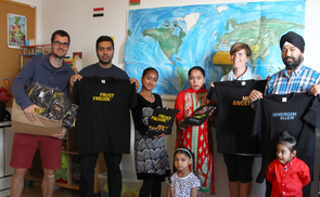 Christoph Schierl und Karin Kurowski mit einer Familie aus Afghanistan und einem einzelnen Fl